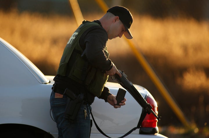 A police officer checking his weapon during the pursuit of suspects after the deadly shooting in San Bernardino.