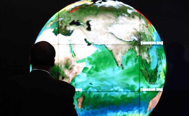 A conference attendee studies a projection of the Earth on the first day of the COP21 United Nations conference on climate change.