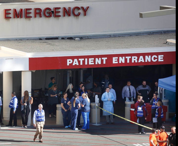 Hospital staff and security guards stand in front of the Loma Linda University Medical Center December 2, 2015 in San Bernard