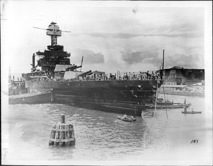 The USS West Virginia gets towed to drydock to start repairs in 1942.