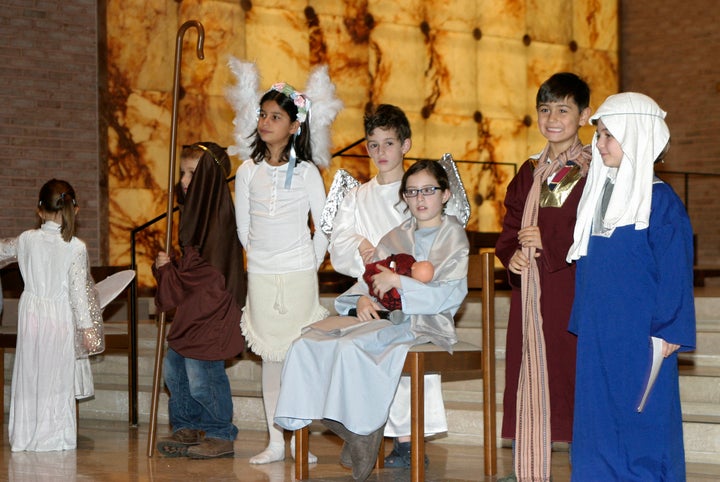 Interfaith Community, a network for Jewish/Christian families, hosts a holiday gathering where kids celebrate Christmas with a pageant and then moved to a separate space to light the Hanukkah menorah. 