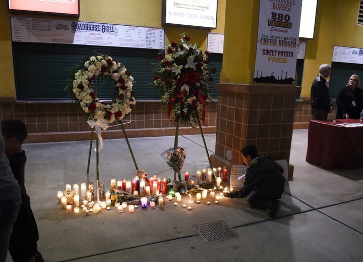 A boy leaves a candle at a memorial at a candlelight vigil at the San Manuel Stadium in San Bernardino, California, December 3, 2015 for victims of the December 2 mass shooting in San Bernardino.