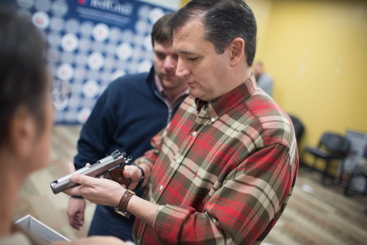 Sen. Ted Cruz (R-Texas) looks over a handgun handed to him by a supporter during a campaign event at CrossRoads Shooting Sports gun shop and range on Friday in Johnston, Iowa.