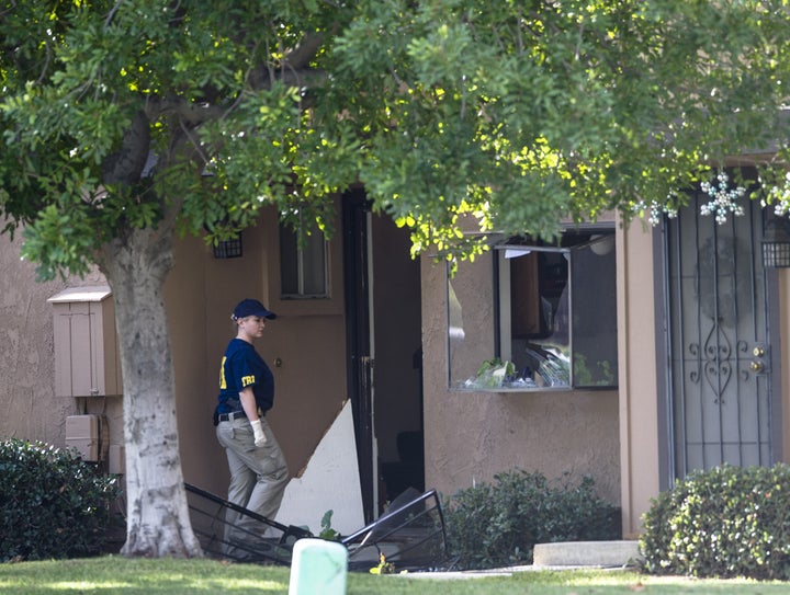 An FBI agent enters the attackers' residence in San Bernardino, California, Dec. 3, 2015.