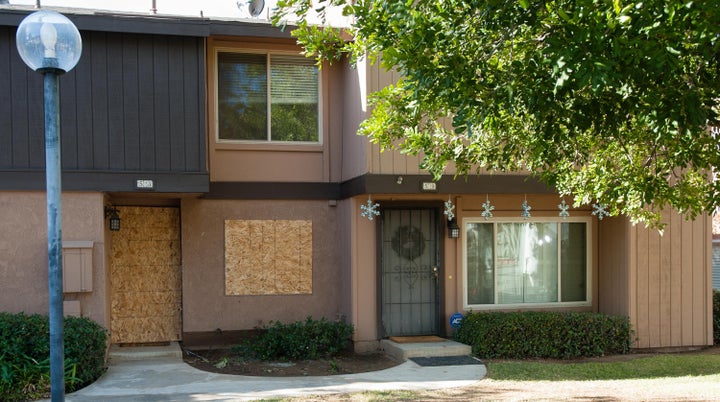 The rented Center Street townhouse of Syed Rizwan Farook and his wife, Tashfeen Malik, is boarded up as holiday decorations and a wreath adorn a neighboring residence on December 5, 2015, in Redlands, California.