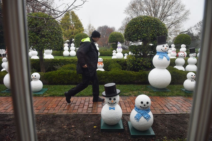 A secret service officers walks by "snow people" at The White House on Dec. 2, 2015.