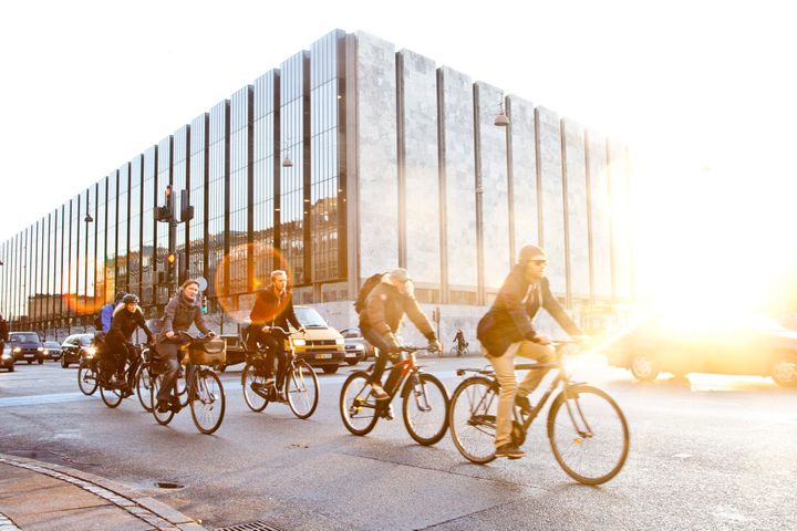 Cyclists ride bikes past the headquarters of Denmark's central bank in central Copenhagen, Denmark.