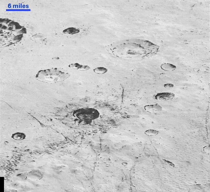 This image reveals new details of Pluto's rugged and icy cratered plains, including layering in the interior walls of craters