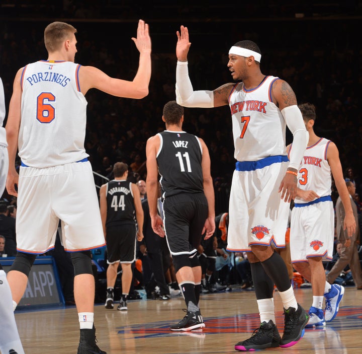 Porzingis, left, and Carmelo Anthony high-five each other in the Knicks' game against the Brooklyn Nets at Madison Square Garden on Dec. 4.