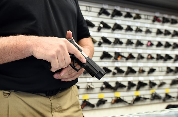 Paul Bastean, owner of the Ultimate Defense Firing Range and Training Center in St. Peters, Missouri, shows a handgun on Nov. 26, 2014. Gun sales have soared following several mass shootings.