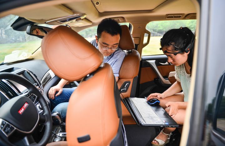 Members of the research team debug the system of the mind-controlled car. 