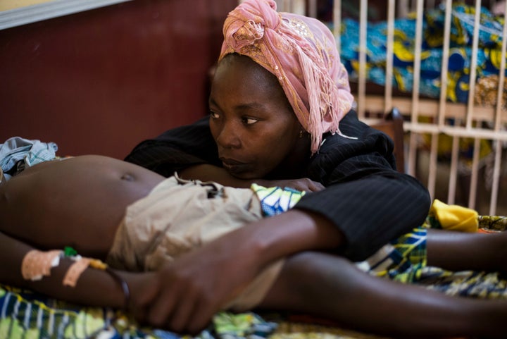 A woman sits beside her son sick with malaria at the pedriatic hospital in Bangui on December 18, 2013. The Central African Republic's interim president and prime minister were to hold talks on December 18 in a bid to end a political rift, as several European countries offered to help quell deadly sectarian violence in the country. Around 600 people have been killed in less than two weeks, according to the United Nations, while some 210,000 people have been forced from their homes in the capital alone.