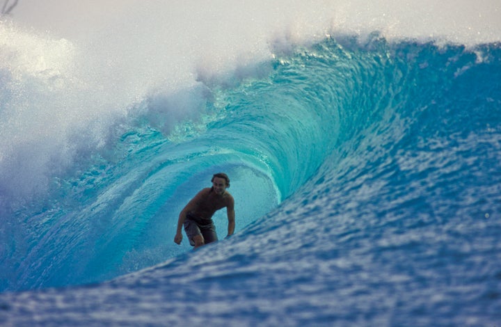 A surfer catches a wave in the Mentawai Islands.