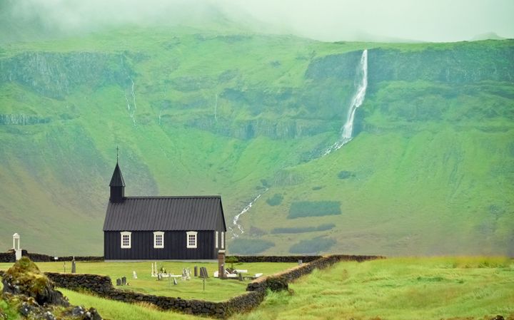 Black church of Budir with landscape and waterfall.