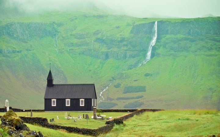 Black church of Budir with landscape and waterfall.