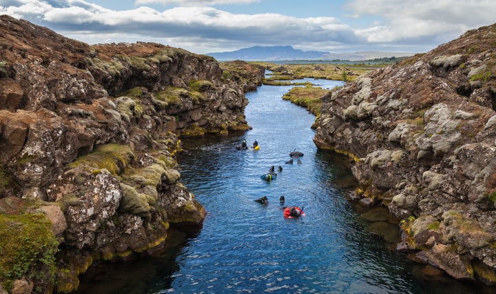 Snorkelers explore the "clearest water on Earth" at Silfra Canyon, the crack between the North American and Eurasian continents.