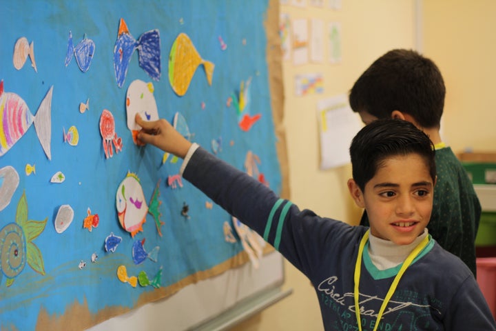 A Syrian boy points to a drawing of a fish during a psychosocial counseling workshop put on by Project Lift.&nbsp;