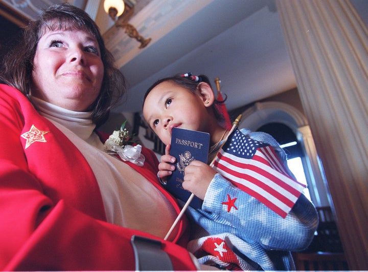 Madison Noelle Hao Collins, 3, celebrates with her mother, Judy Collins, and her new U.S. passport at Boston's Faneuil H