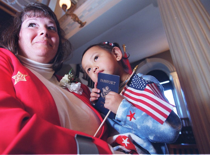 Madison Noelle Hao Collins, 3, celebrates with her mother, Judy Collins, and her new U.S. passport at Boston's Faneuil Hall on Feb. 27, 2001.