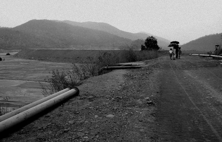 People walk past the contaminated river.