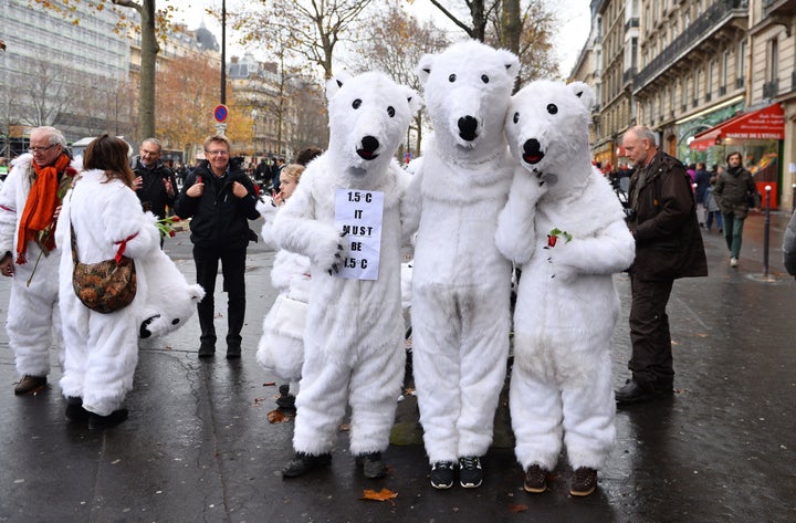 People wear polar bear costumes during an activist demonstration near the Arc de Triomphe at the Avenue de la Grande Armee boulevard in Paris on Dec. 12, 2015. A proposed 195-nation accord will help curb emissions of the heat-trapping gases that threaten to wreak havoc on Earth's climate system.