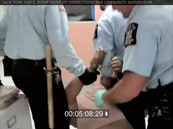 In a screenshot from the video, officers are seen dragging Strickland by the arms while he is still handcuffed.