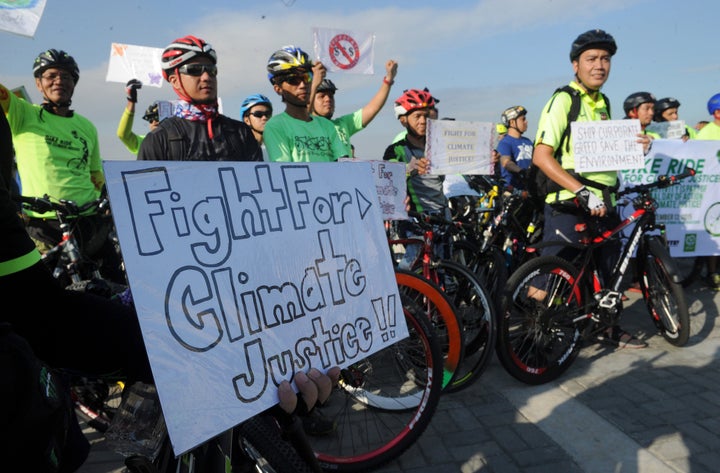 Environmentalists take part in a bicycle ride to show solidarity for the global movement for climate justice in Manila on December 13, 2015. Cheering envoys from 195 nations approved a historic accord in Paris to stop global warming, offering hope that humanity can avert catastrophic climate change and usher in an energy revolution.