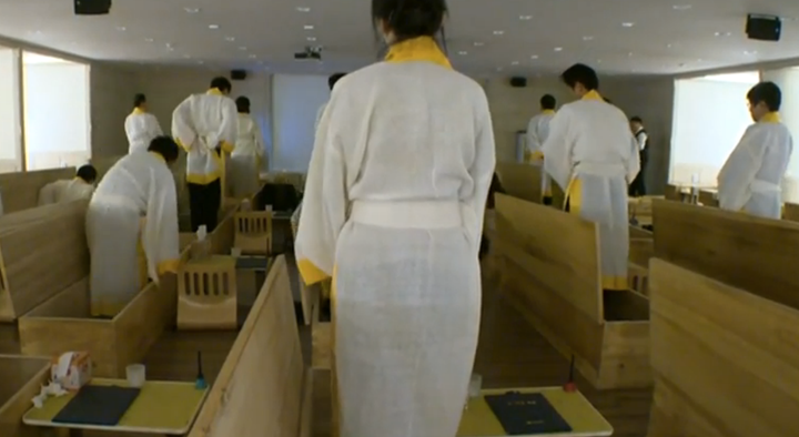 Program participants prepare to enter their caskets at the Hyowon Healing Center. They will stay in these coffins for 10 minutes while contemplating the experience.