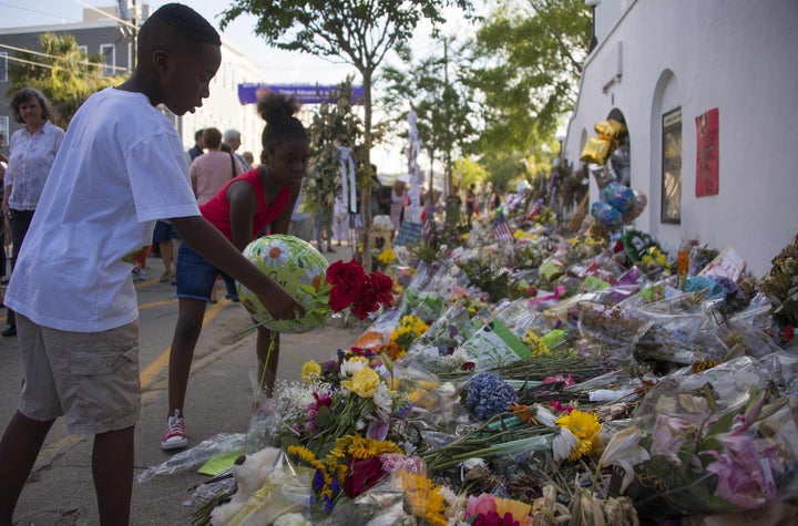 Children place flowers outside Emanuel AME Church in Charleston, South Carolina, where nine churchgoers were shot dead during Bible study on June 17.