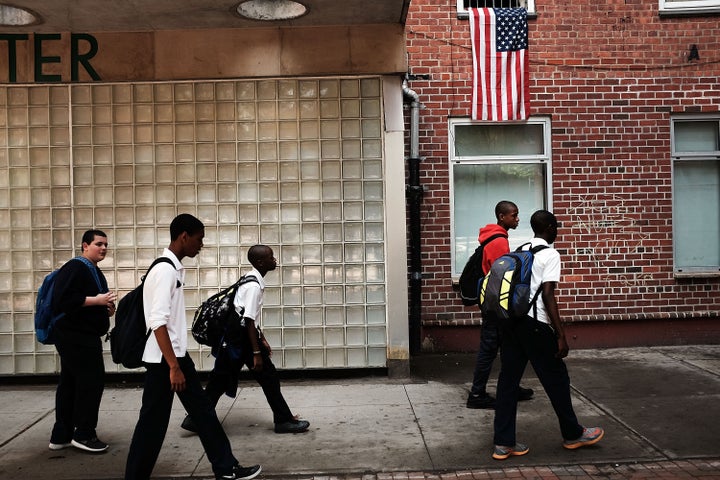 NEW YORK, NY - MAY 19: Residents stand outside of an East Harlem public housing complex on May 19, 2015 in New York City. New