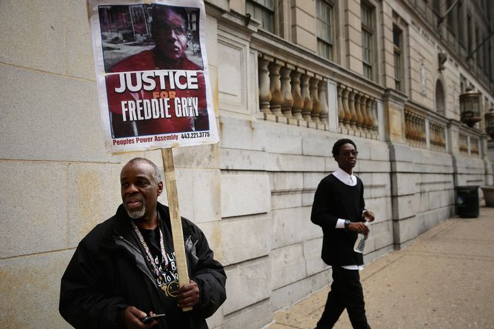 Demonstrators Arthur Johnson Jr. (L) and Shai Vaughn stand outside the Baltimore City Circut Courthouse East during the trial of police Officer William G. Porter December 14, 2015 in Baltimore, Maryland.