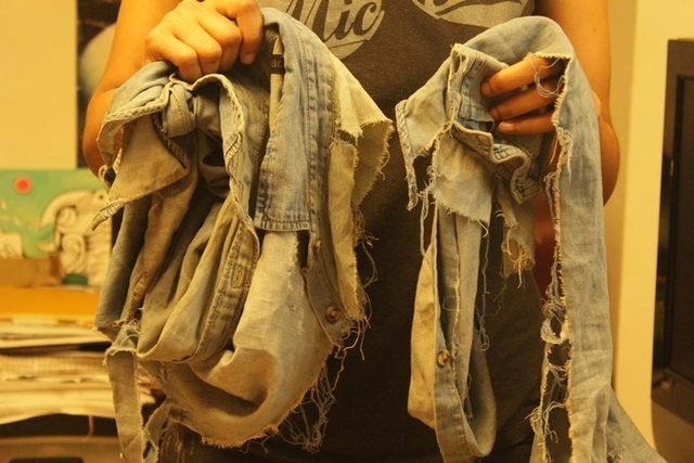 <i></i>Dorceant holds up some of her clothes she says were destroyed during her alleged assault.