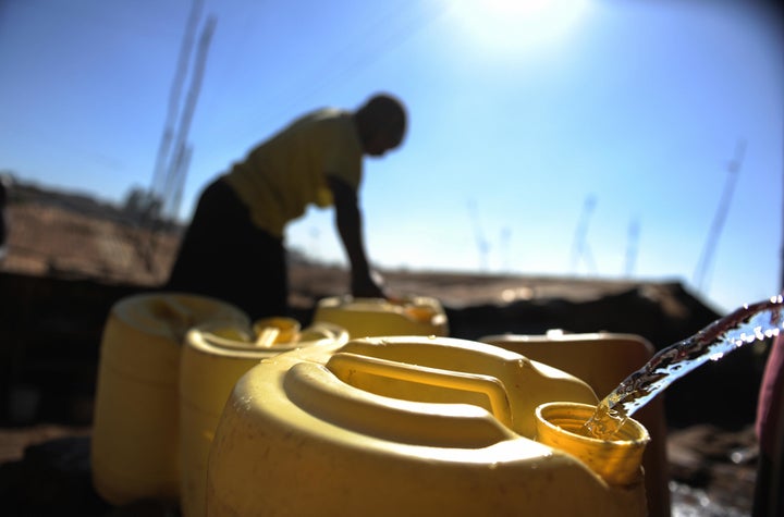 A Kenyan woman handles a jerry can water jug at a distribution site in the Kibera slum of Nairobi, Kenya, on March 21, 2009.