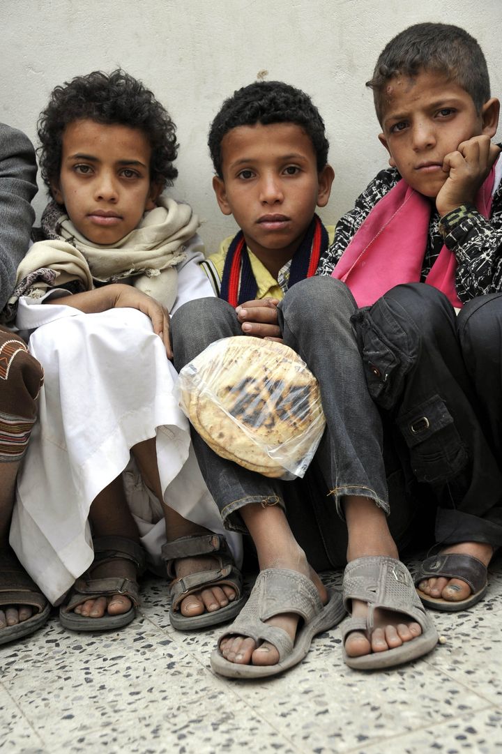 SANAA, YEMEN - JUNE 26: Yemenis wait in line at a school garden in Sumeyla district of capital Sanaa to receive food aids provided by the union of non-governmental organizations in war-stricken Yemen on June 26, 2015. According to a recent UN report, more than 21 million people are in desperate need of humanitarian assistance in Yemen.