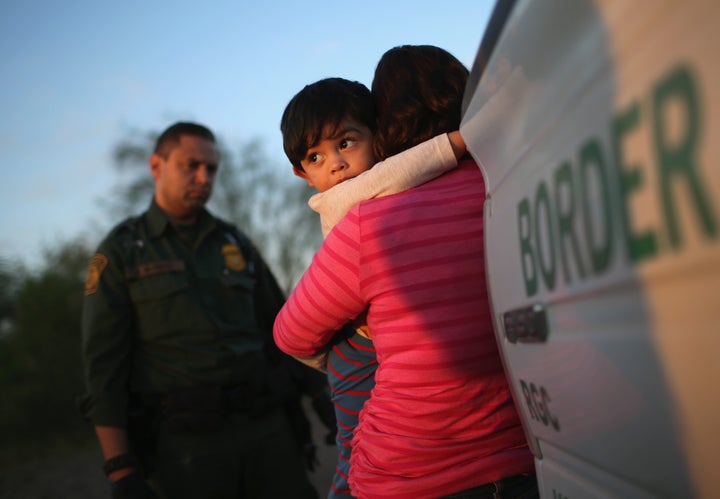 A one-year-old from El Salvador clings to his mother after she turned themselves in to Border Patrol agents on December 7, 2015 near Rio Grande City, Texas.