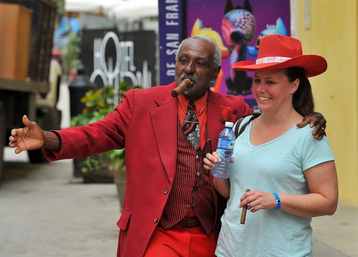 tourist poses with a Cuban man as she visits the Old Havana, on December 16, 2015.