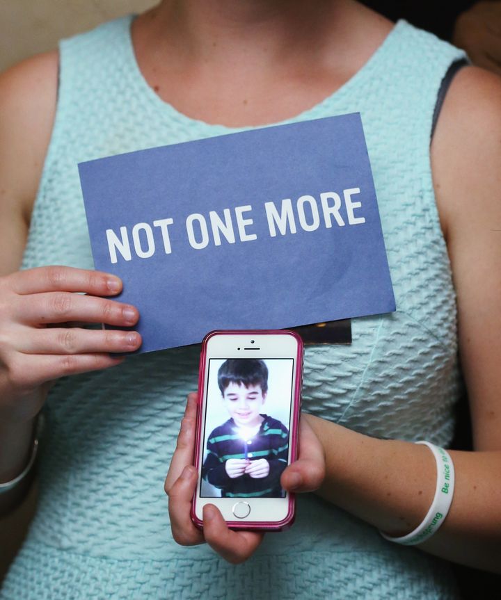 Danielle Vabner holds a image of her little brother Noah Pozner, who was shot and killed in the Newtown Connecticut. massacre, during a news conference on gun safety, on June 17, 2014 in Washington, DC.