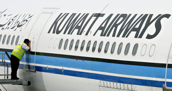 In this file photo from 2006, a crew member peeks inside the cabin of a Kuwait Airways Airbus A340. The airline suspended flights between New York and London this week rather than sell tickets to Israeli citizens. 