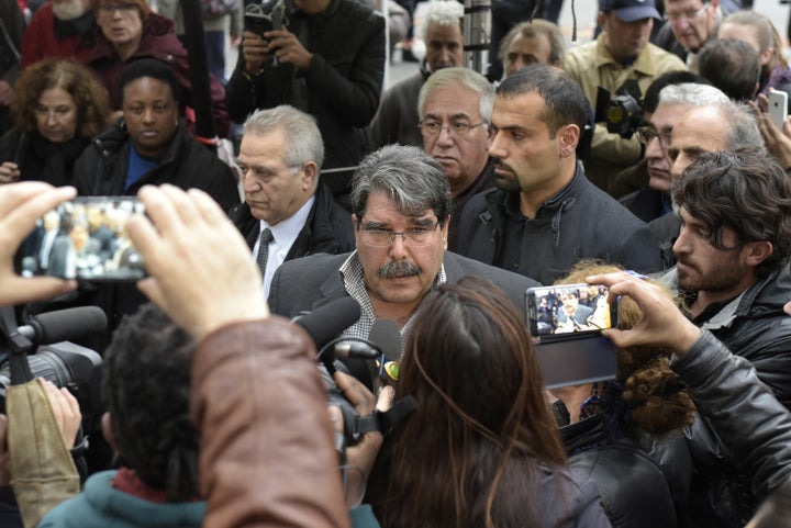 Salih Muslim Muhammad, chairman of the PYD, answers journalists' questions as he arrives to pay tribute to the victims of the attacks claimed by Islamic State which killed at least 129 people and left more than 350 injured, on November 17, 2015 in front of the Bataclan theatre in Paris.