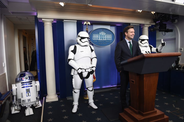White House press secretary Josh Earnest appears in the White House Briefing Room with R2D2 and two Stormtroopers ahead of a