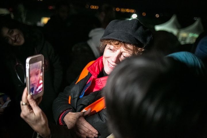 Susan Sarandon shows a video of her granddaughter to mothers and their children in a Greek refugee camp. 