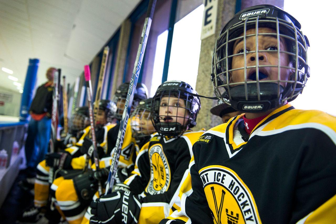 Players in the Fort Dupont Ice Hockey Club watch a game from the bench in March 2014.