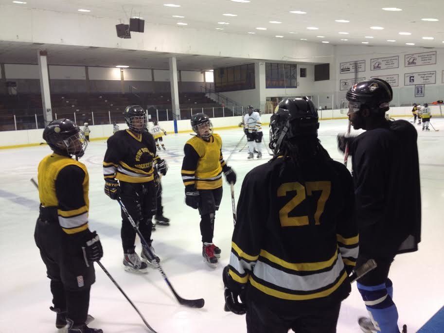 Duante' Abercrombie, right, instructs players in the Fort Dupont Ice Hockey Club during a practice in Dec. 2014. Abercrombie learned to skate at Fort Dupont, played minor league hockey, and returns to coach when he can.