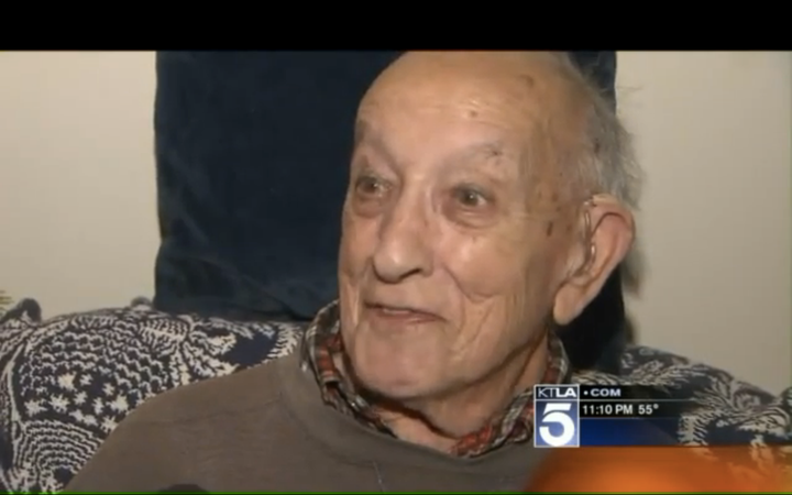 Herman Perry smiles while in the surprise company of several LAPD officers and his neighbor, Amy