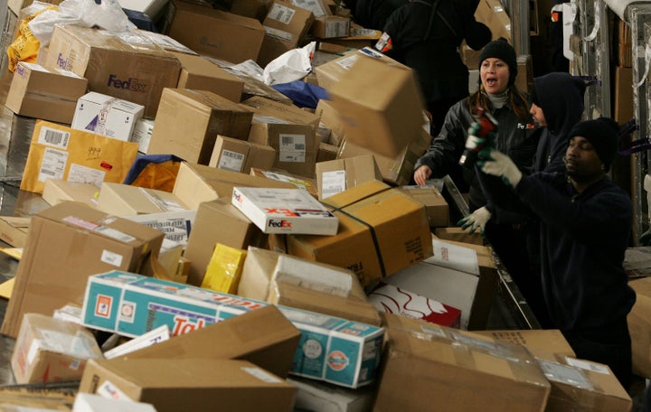 FedEx workers sort through a pile of boxes at the FedEx sort facility at the Oakland International Airport, Dec. 18, 2006, in Oakland, California.