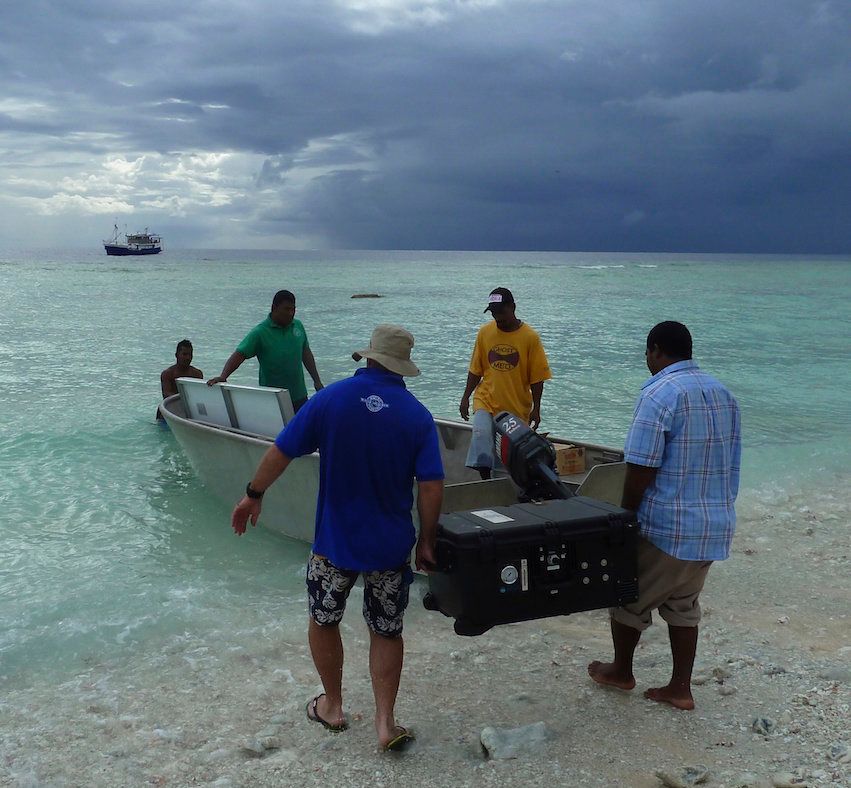 Workers deliver a solar-powered desalination machine to one of the outer islands.