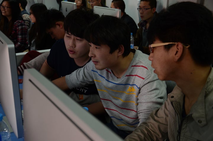 Students in an iOS development class at Uplooking's Beijing center collaborate.