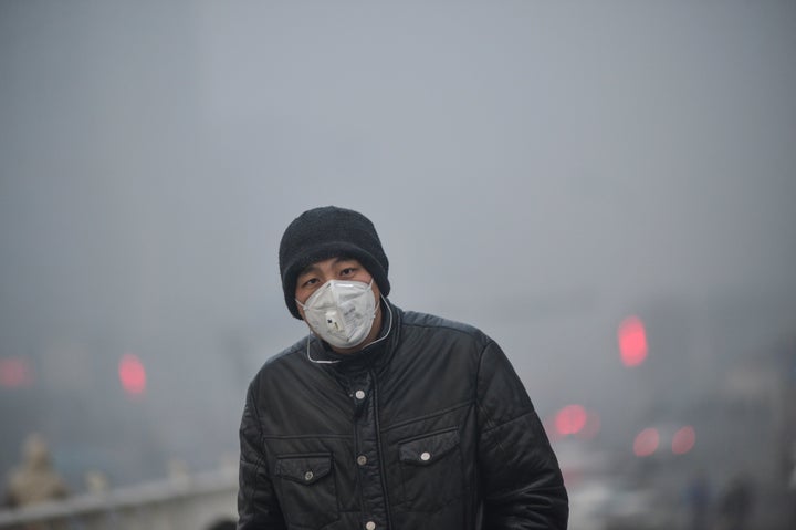 A pedestrian walks along a street in heavy smog in Tianjin, China.