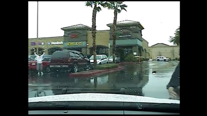 Arturo Arenas-Alvarez is seen approaching police with his hands in the air after exiting his red SUV, leaving his toddler inside.