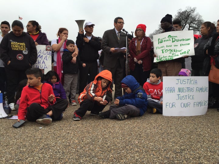 Children sit on the ground during a protest outside the White House over the Obama administration's plans to deport more families to Central America.